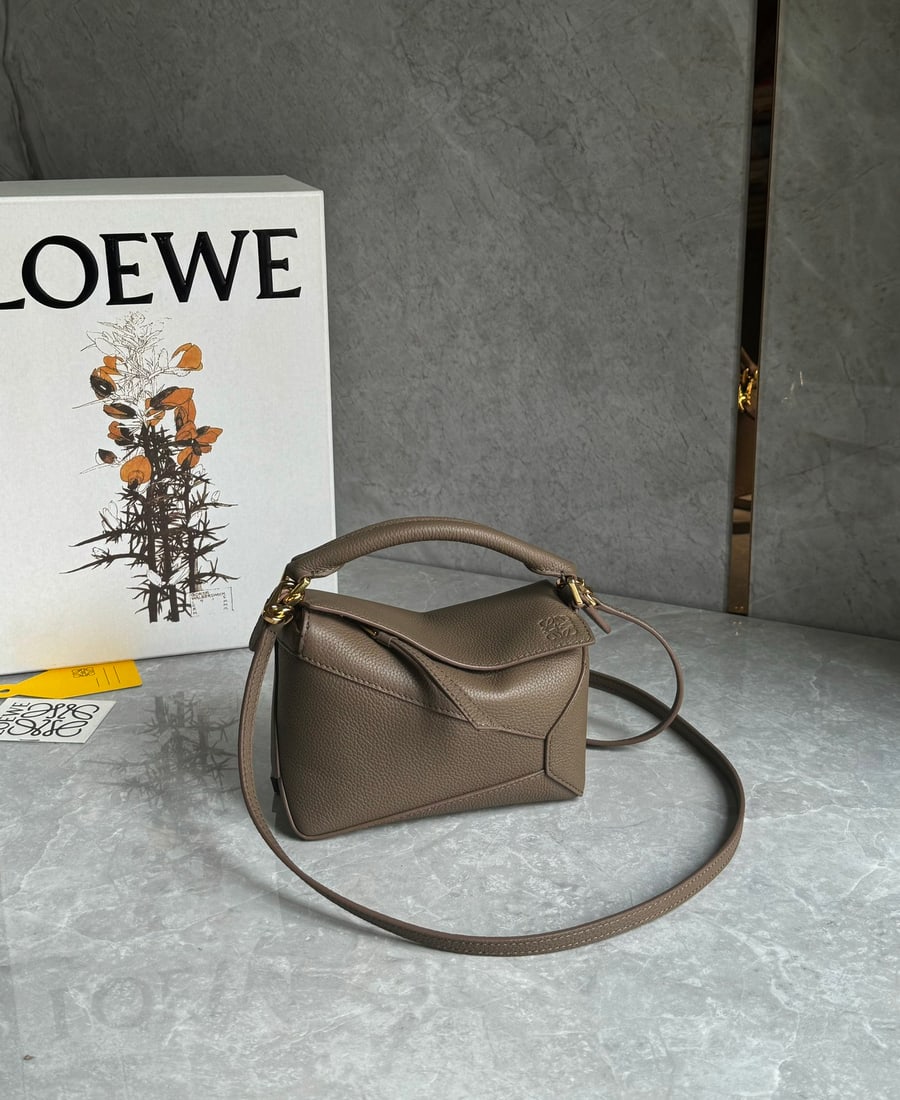 LOEWE: LOEWE Puzzle in taupe! The mini adjustable shoulder strap adds a youthful touch and visual depth. The Puzzle's ample capacity makes it incredibly practical! It's not just a stylish accessory. Size: