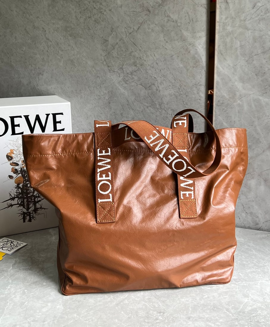 LOEWE: The LOEWE Fold Shopper tote bag diaper bag has a great, natural, relaxed yet stylish silhouette. Made of lightweight and comfortable paper-textured cowhide, it folds flat at the bottom and is a must-h