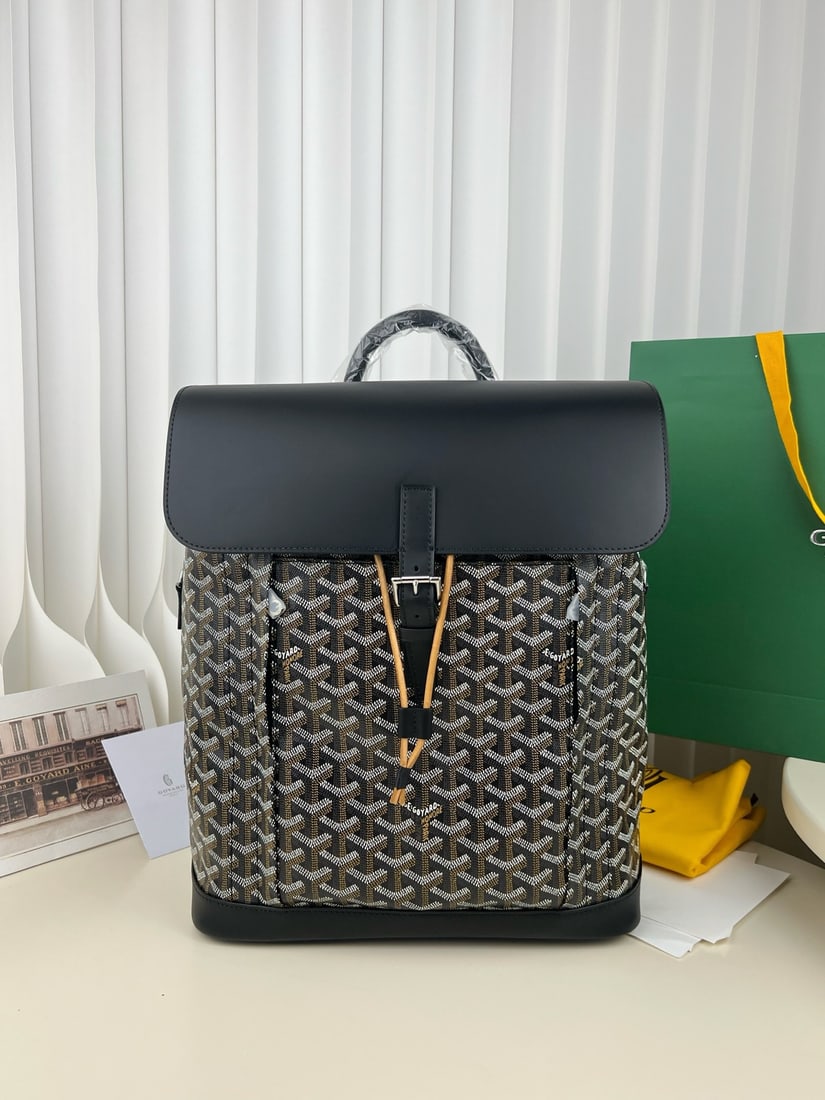Goyard Alpin MM: The Goyard Alpin MM men's flap backpack is a design by Goyard specifically for urban adventurers. A reinvention of the brand's renowned Steamer bag, it was a loyal companion to 20th-century travelers.