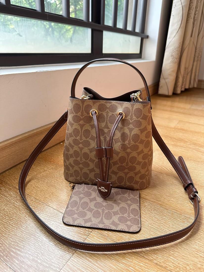 Coach Rowan: The actual product is so beautiful, the camera can't capture its beauty. This Coach classic monogram Rowan drawstring shoulder crossbody bucket bag features a detachable long short strap for multiple 