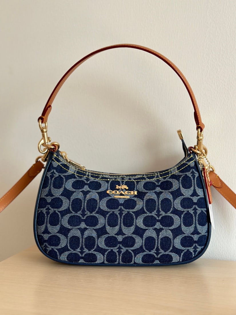 Coach Teri: Coach Teri Denim Shoulder Bag with Champagne and Leather Trim - A stylish and versatile denim shoulder bag crossbody handbag in a striking blue color. The leather patch and accessories add to its
