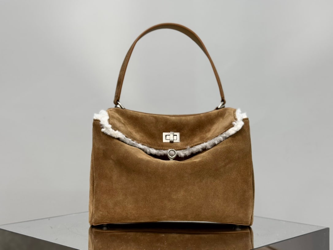 Balenciaga Rodeo Bag: The Balenciaga Rodeo Bag in dark brown suede is a must-mention for Fall Winter. Popular throughout 2024, the Rodeo bag pioneered a new style and was extremely popular among fashionistas. Its relaxed, 