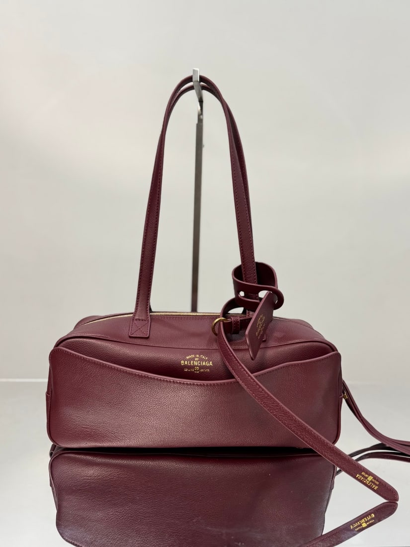Balenciaga Carrie Bowling: The Balenciaga Carrie Bowling bag boasts a unique, flowing curved shape, reminiscent of a musical note, making it instantly recognizable on the street. Its distinctive charm is undeniable. The double 