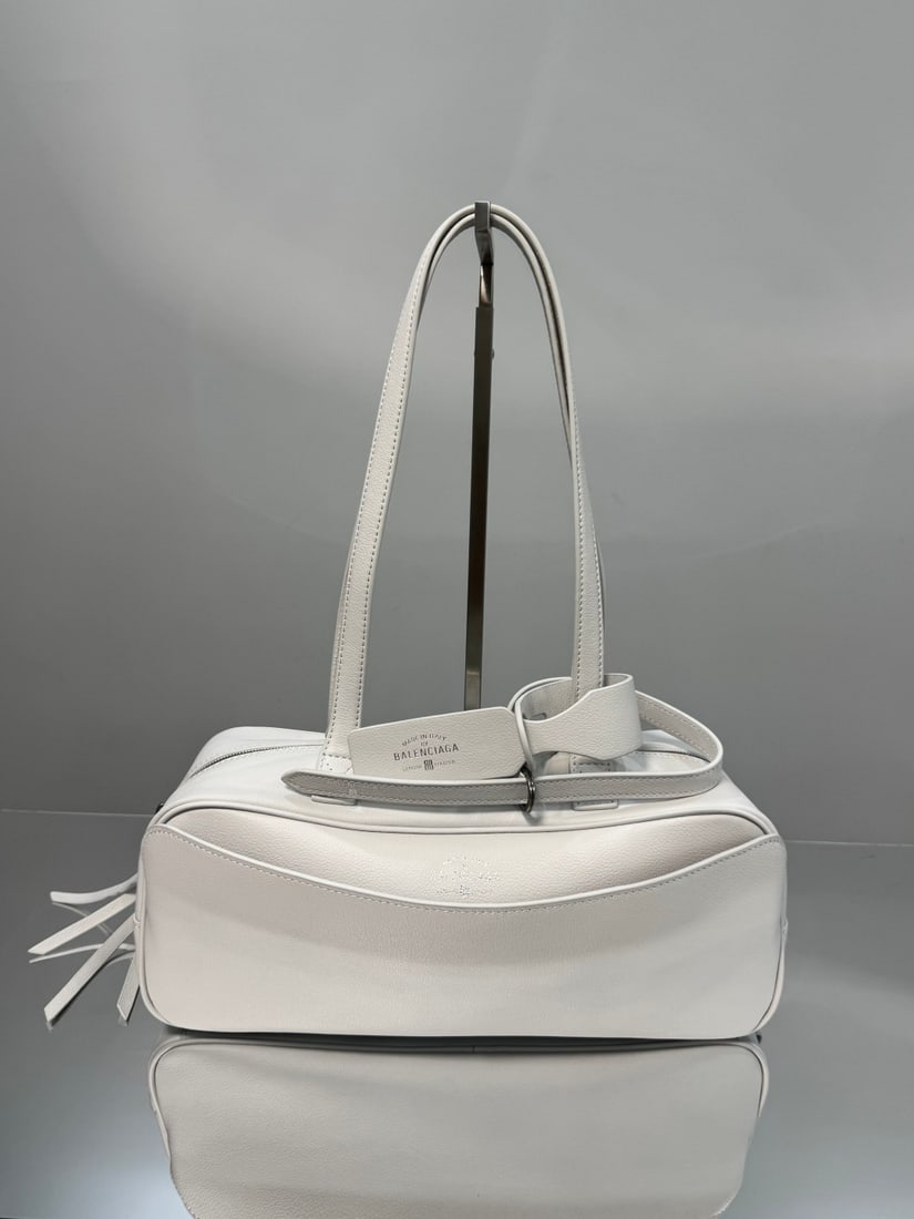 Balenciaga Carrie Bowling: The Balenciaga Carrie Bowling bag boasts a unique, flowing curved shape, reminiscent of a musical note, making it instantly recognizable on the street. Its distinctive charm is undeniable. The double 