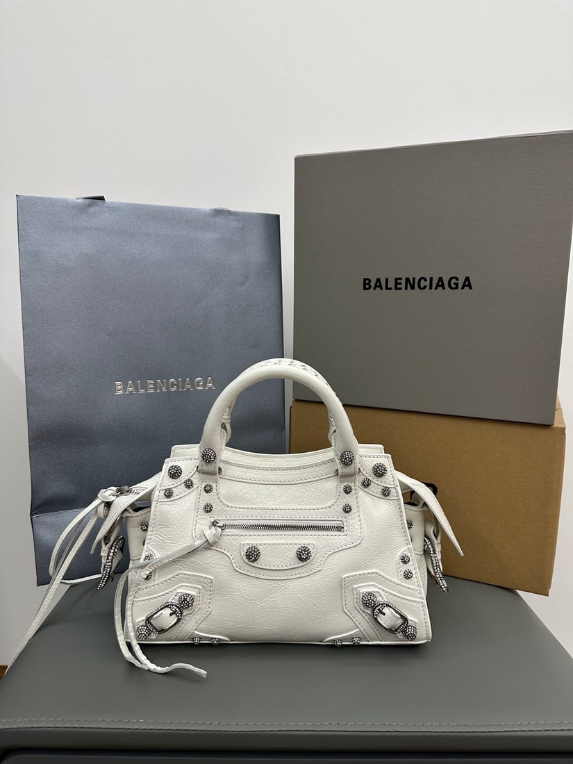 Balenciaga Neo Cagole Motorcycle Bag: The Balenciaga Neo Cagole motorcycle bag, adorned with waxed white diamonds, features a heart-shaped mirror. Beneath its cool exterior lies a sweet heart; carrying it instantly elevates your style. A 