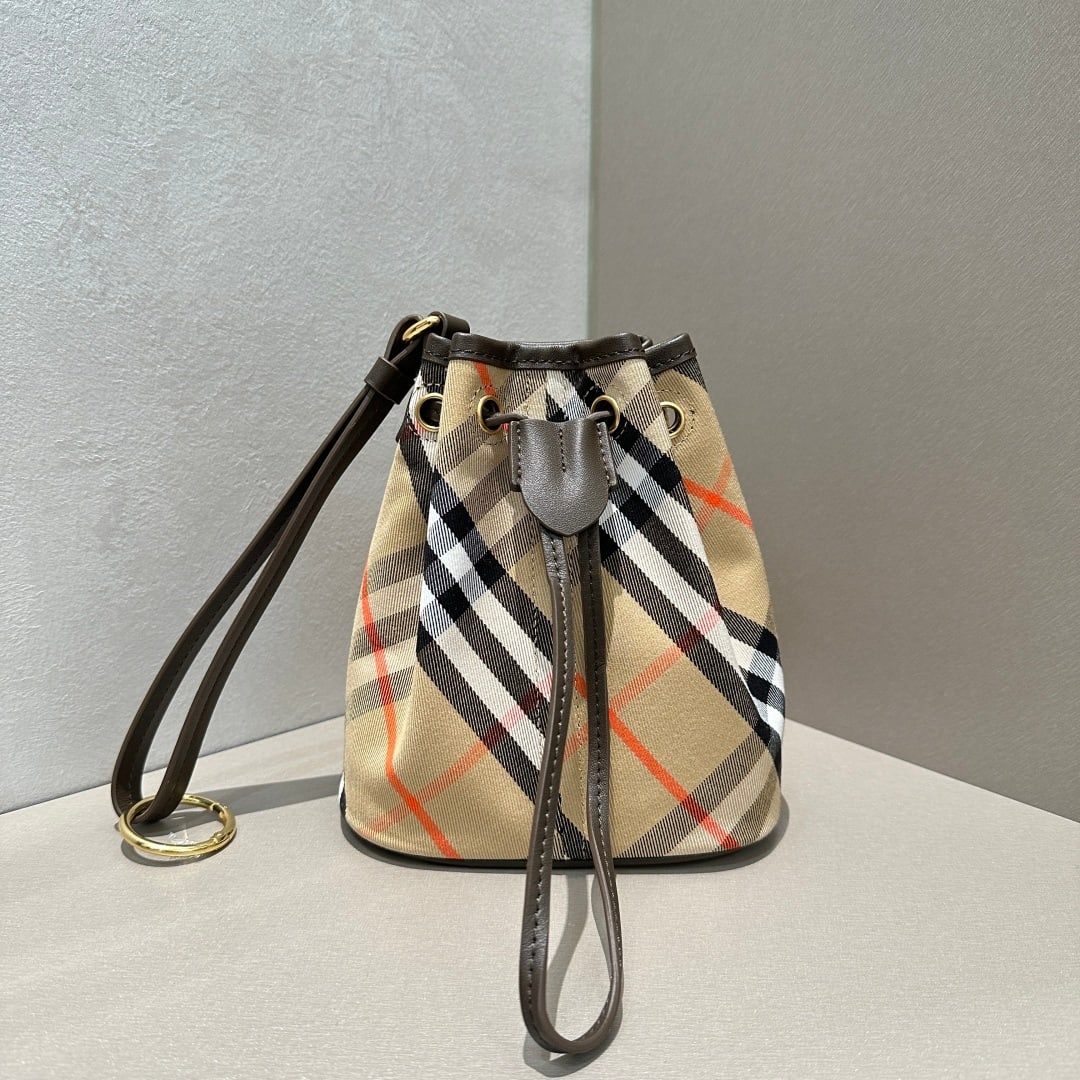 Burberry: This exquisite clutch bag is crafted from soft cotton twill fabric and adorned with Burberry's signature jacquard check pattern. It features a smooth calfskin drawstring and a wrist strap. The leather