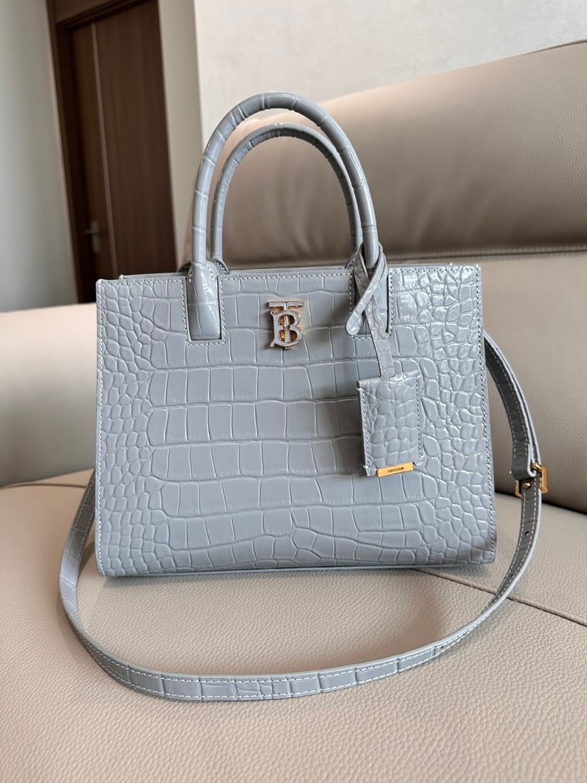 Burberry: This Burberry tote bag is crafted from Italian-tanned crocodile-embossed leather with a striking Thomas Bur logo. Its sophisticated design includes multiple pockets and a leather-wrapped mirror charm.