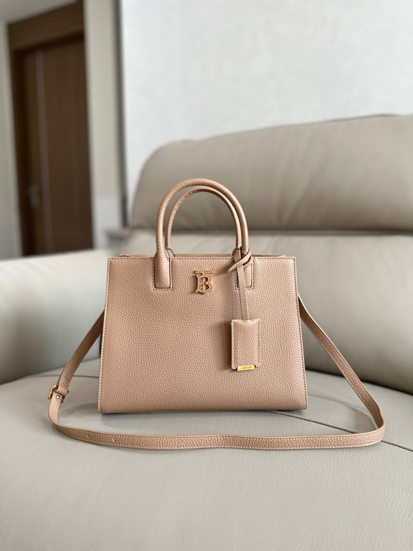 Burberry: This structured Burberry tote bag is crafted from Italian-tanned grained leather and features a striking Thomas Burberry logo with a glossy finish. The sophisticated design includes multiple pockets a