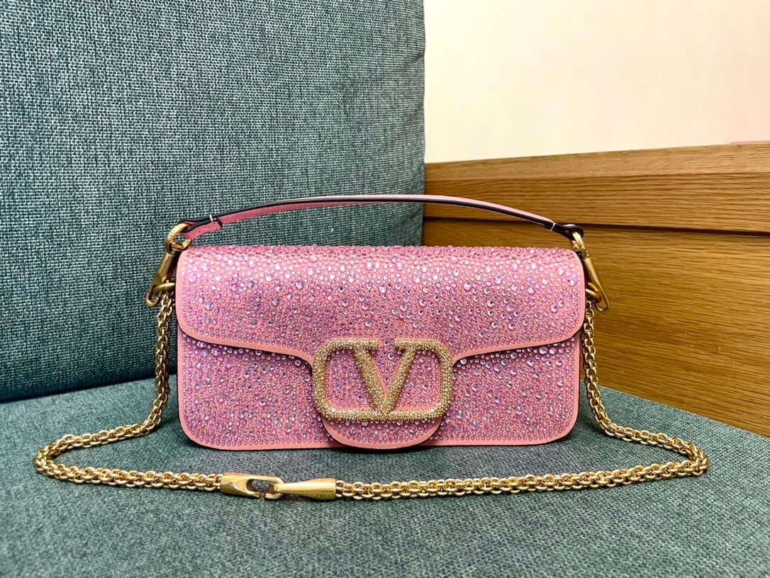 Valentino: This Valentino calfskin handbag features a pink rhinestone buckle and a vintage brass distressed finish. It has a magnetic closure and a frosted leather lining. A wonderful gift for you or your loved 