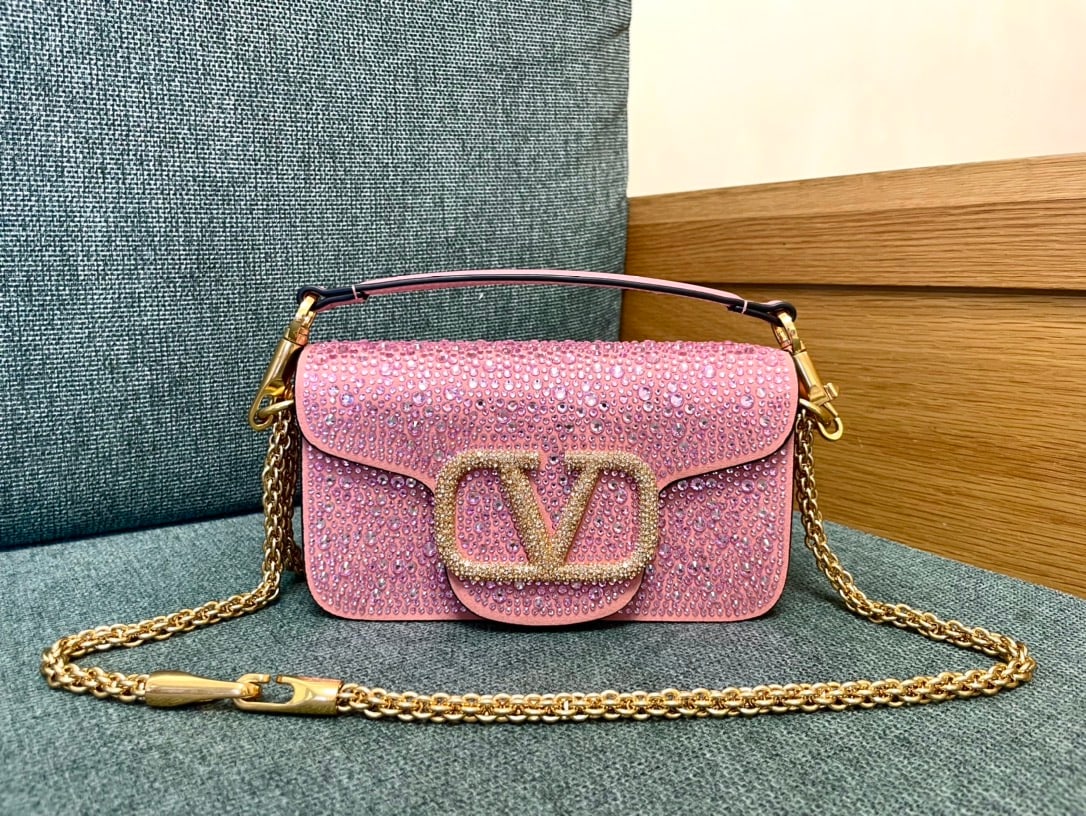 Valentino: This Valentino calfskin handbag features a pink rhinestone buckle and a vintage brass distressed finish. It has a magnetic closure and a frosted leather lining. A wonderful gift for you or your loved 
