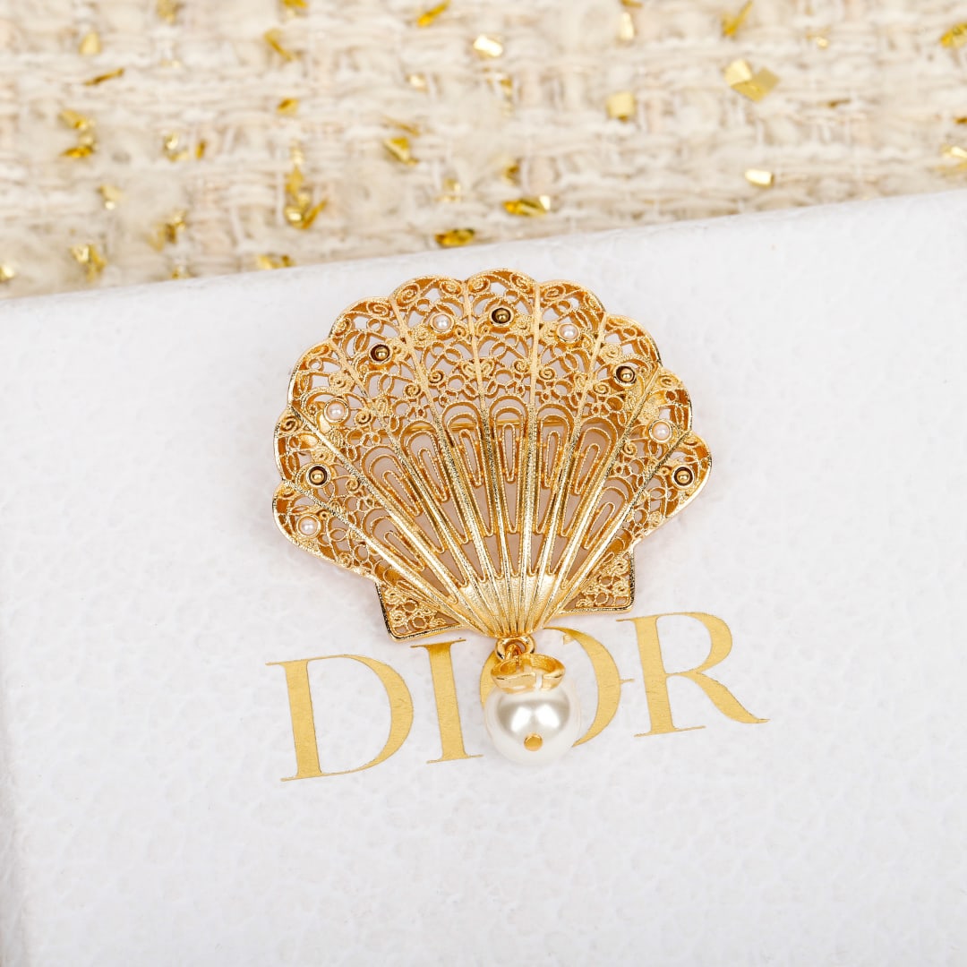 DIOR Shell and Pearl Brooch: Dior's 2025 Early Spring collection features a seashell and pearl brooch inspired by the ocean. The 3D openwork mesh with a gold finish and exquisite metal structure creates a romantic and beautiful l