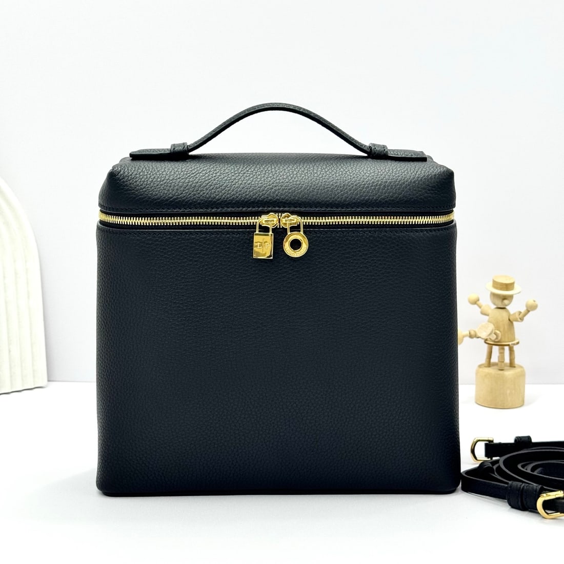 Loropiana Extra Pocket L23.5 Backpack: The Loropiana Extra Pocket L23.5 backpack, with its black exterior and gold hardware, transforms a minimalist design into a spacious square bag that elongates towards the base. Crafted from calfskin, 
