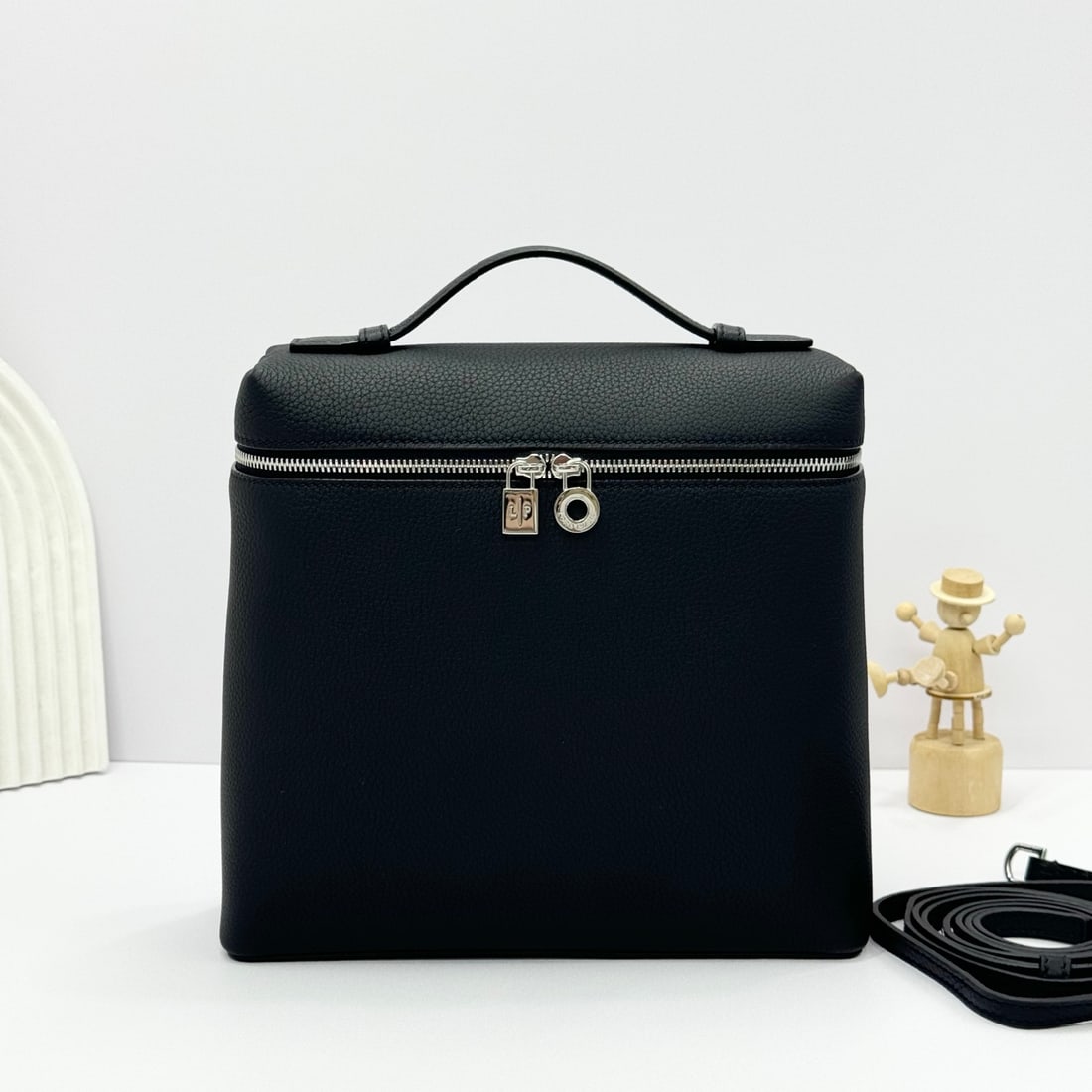 Loropiana Extra Pocket L23.5 Backpack: The Loropiana Extra Pocket L23.5 Black Backpack transforms a minimalist design into a large-capacity square bag, elongated towards the base. Crafted from calfskin, the subtle hammered texture enhances