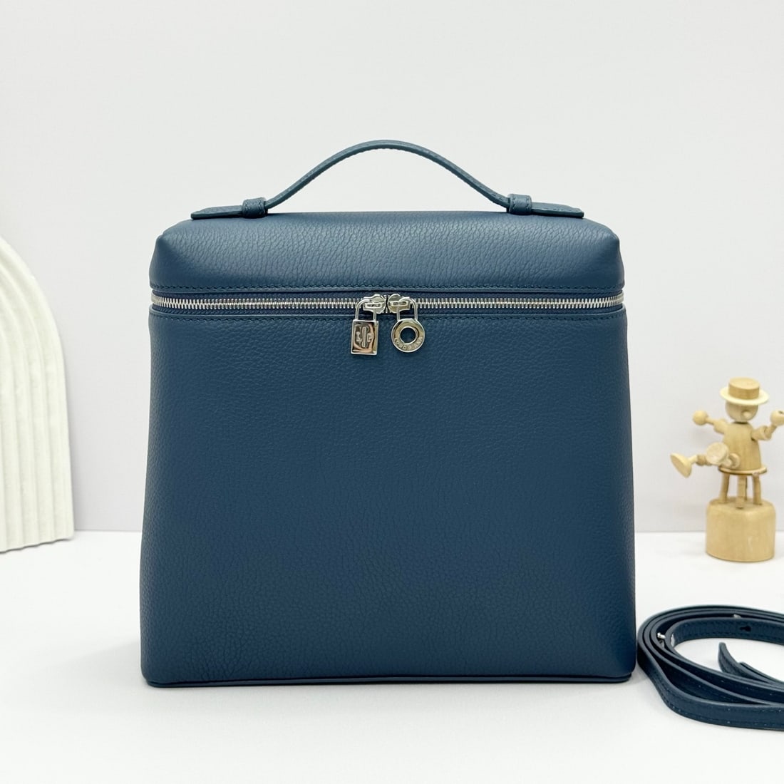 Loropiana Extra Pocket L23.5 Backpack: The Loropiana Extra Pocket L23.5 backpack in Iris Blue transforms a minimalist design into a spacious square bag, elongated towards the base. Crafted from calfskin, the subtle hammering enhances the l