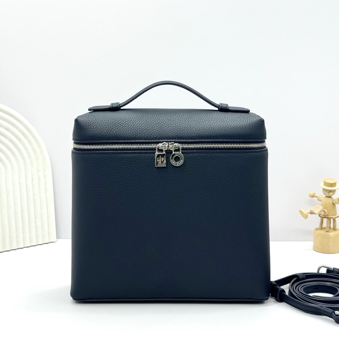 Loropiana Extra Pocket L23.5 Backpack: The Loropiana Extra Pocket L23.5 backpack in Midnight Blue transforms a minimalist design into a large-capacity square bag, elongated towards the base. Crafted from calfskin, the subtle hammering enha