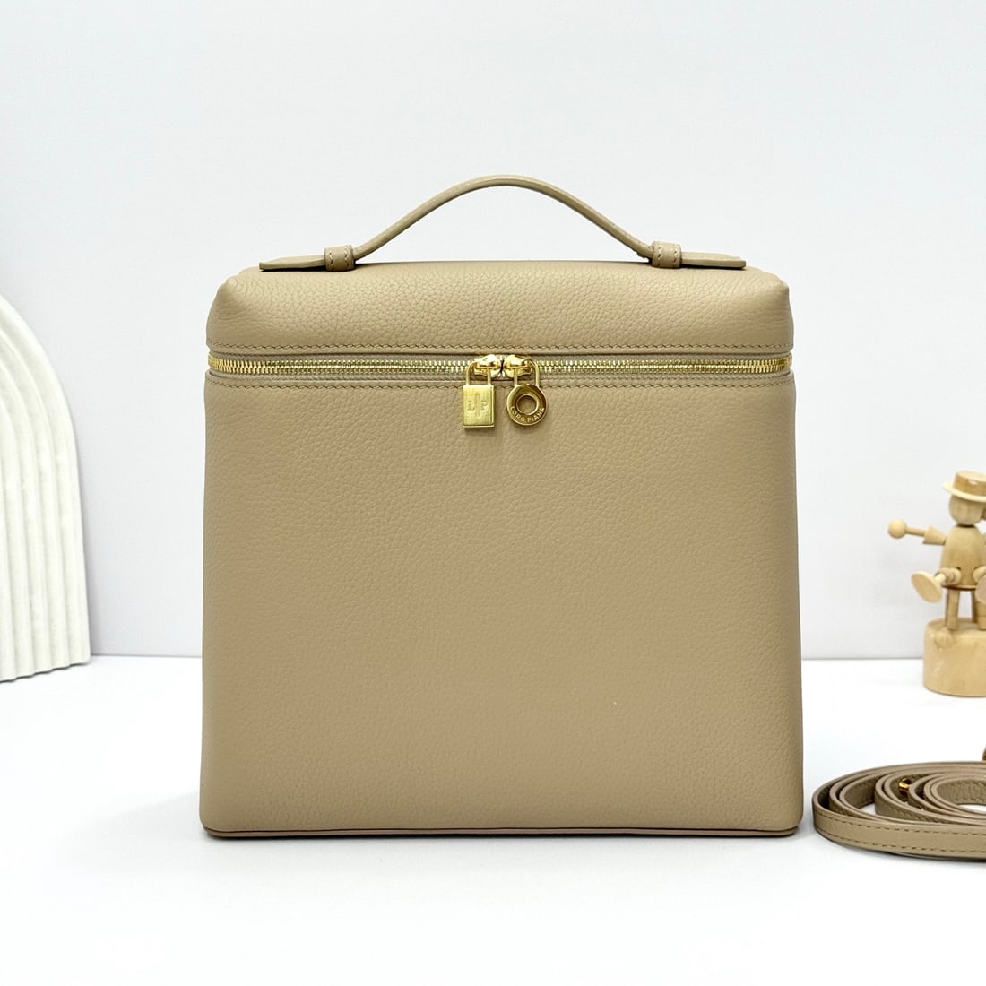 Loropiana Extra Pocket L23.5 Backpack: The Loropiana Extra Pocket L23.5 backpack in a light frankincense color with gold hardware transforms a minimalist design into a large-capacity square bag, elongated towards the base. Crafted from cal