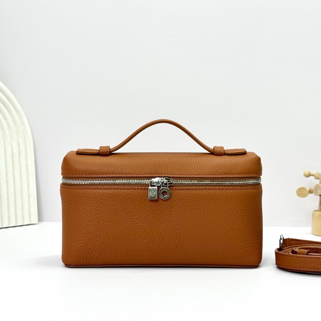 Loropiana Extra Pocket L19 Clutch: Loropiana Extra Pocket L19 Tobacco Brown with Silver Buckle: This is a functional clutch with a wide opening, combining classic style and minimalist design. The body is made of calfskin with a subtle 