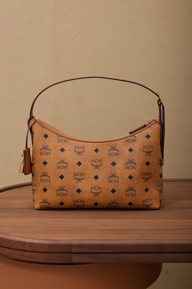 MCM Aren Hobo Underarm Shoulder Bag: The MCM Aren Hobo shoulder bag with its all-over monogram print offers a modern reinterpretation of classic casual style, achieving an ideal balance between softness and structure. This small Aren Hob