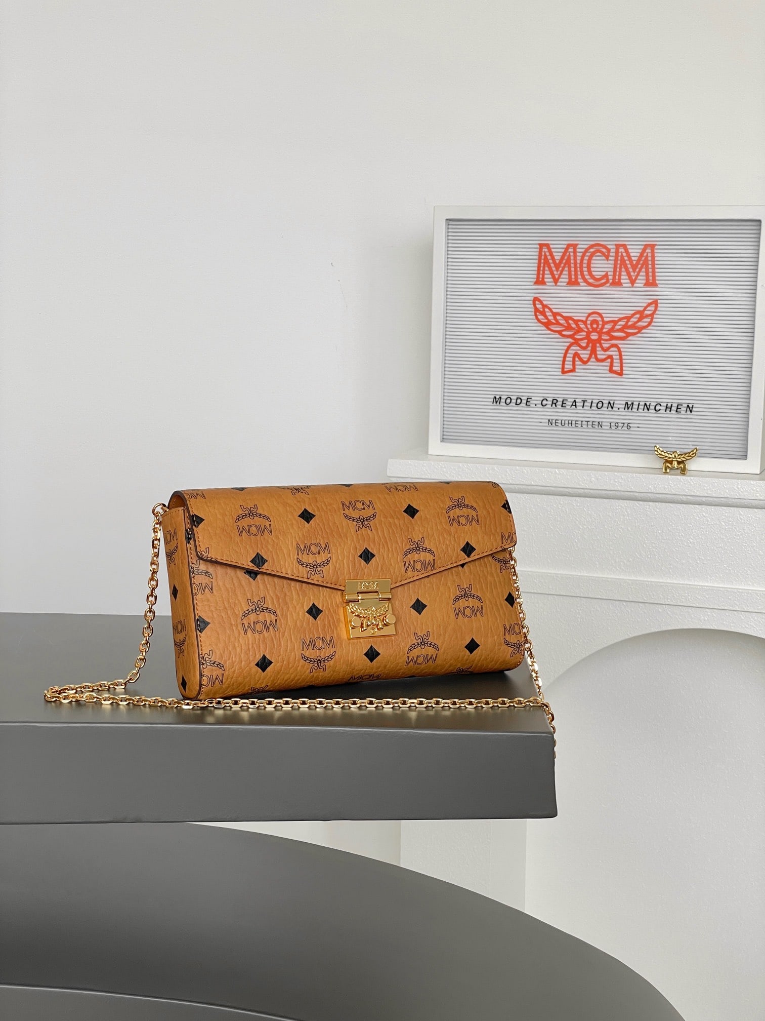 MCM TRACY VISETOS Medium Envelope Pouch (Pure Chain Terms): MCM TRACY VISETOS Medium Envelope Bag with All-Over Monogram Print and Pure Chain Strap. This exceptional Tracy crossbody bag is crafted from Italian Visetos and Nappa leather. This classic tote bag f