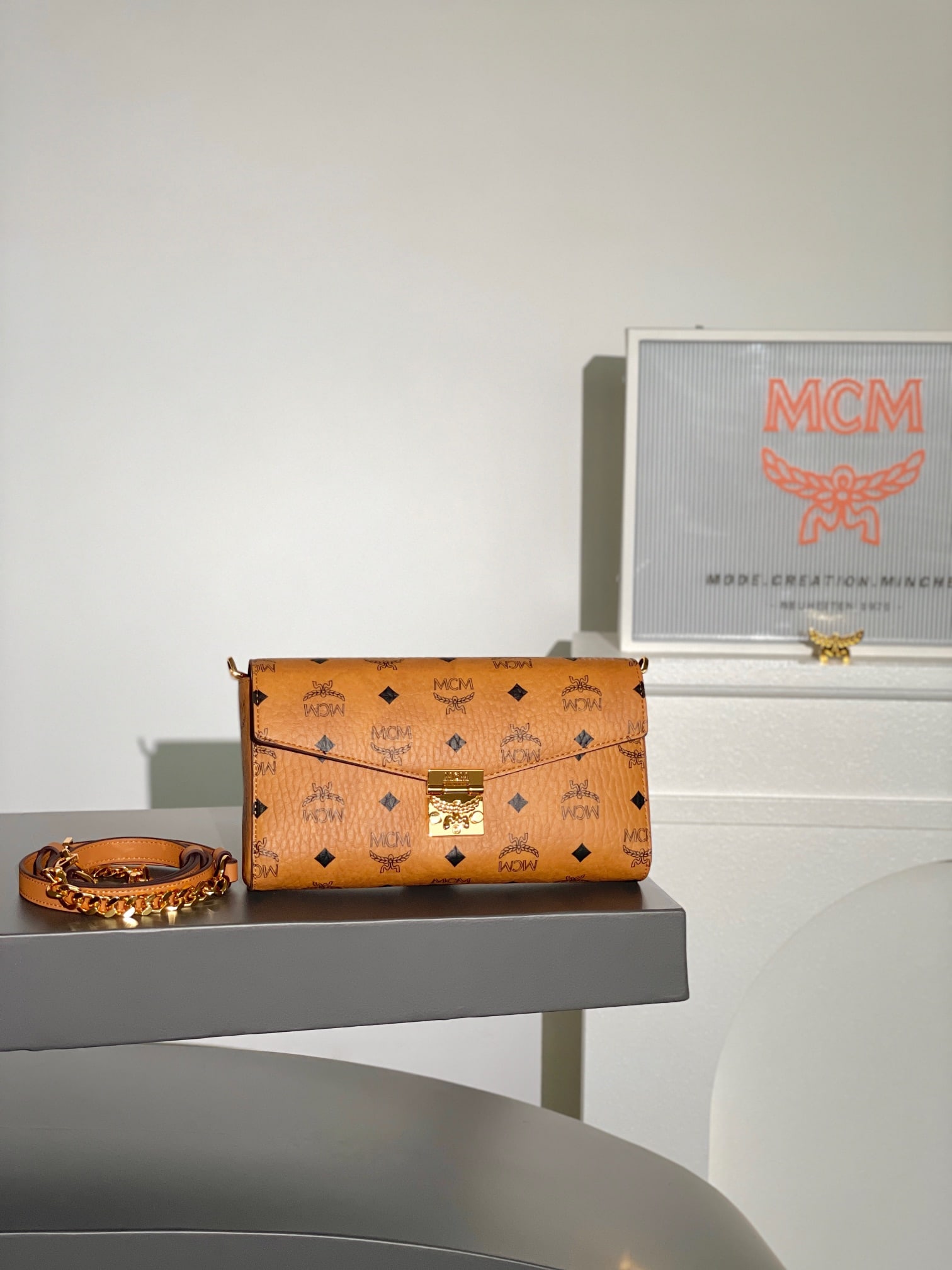 MCM TRACY VISETOS Medium Envelope Bag with Leather Shoulder Strap and Chain: MCM TRACY VISETOS Medium Envelope Bag with Chain Strap and All-over Monogram Print. This exceptional Tracy crossbody bag is crafted from Italian Visetos and Nappa leather. This classic tote bag featur