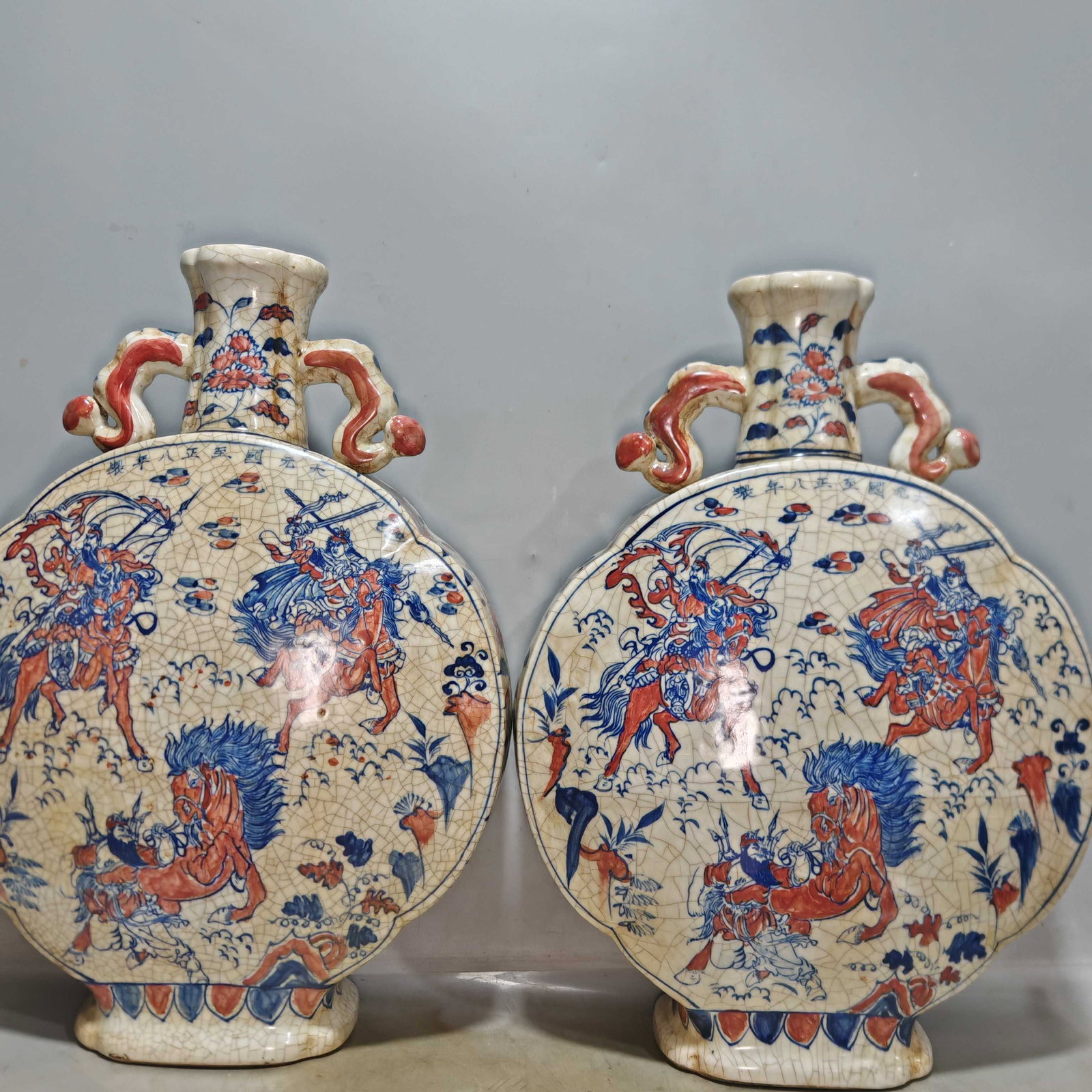 A hand-painted blue-and-white underglaze red moon-shaped vase depicting the Three Heroes battling: A hand-painted blue-and-white underglaze red moon-shaped vase depicting the Three Heroes battling L?? Bu, made in the eighth year of the Zhizheng era of the Yuan Dynasty. Provenance:From an old privat