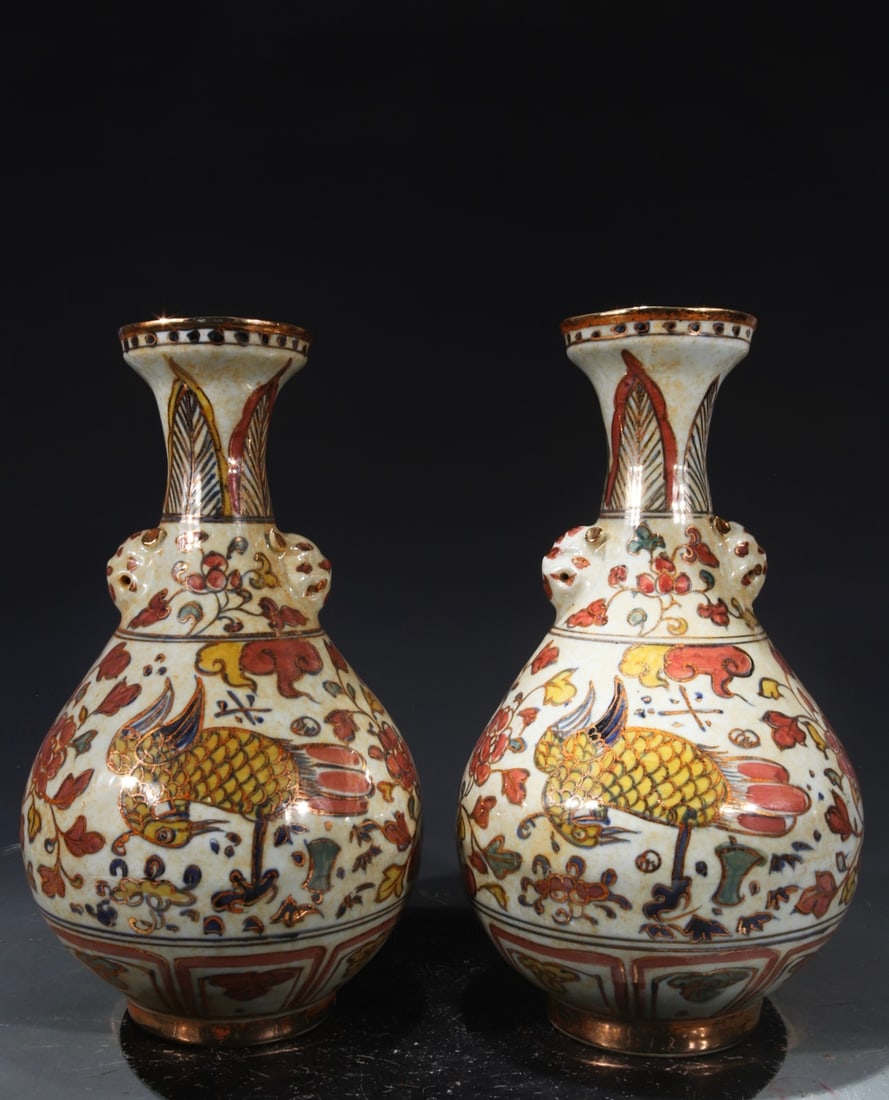 A pair of polychrome gilt-painted vases with crane and animal head designs, bearing the mark "Made (1 of 8)