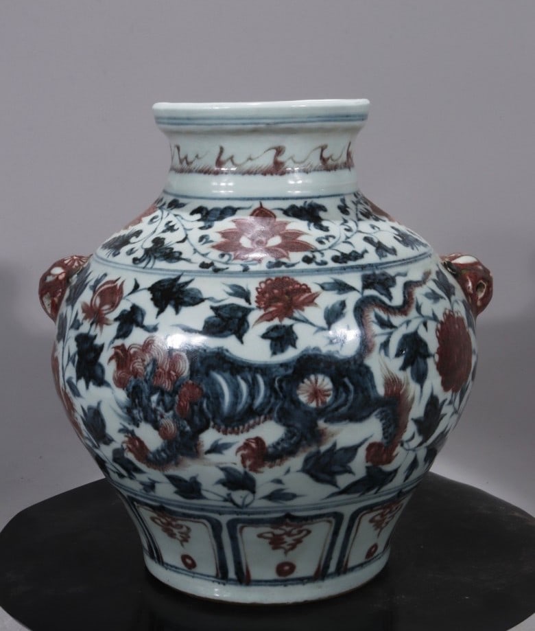 An old blue-and-white underglaze red lion-shaped jar with floral and animal-head handles from a: A blue-and-white underglaze red lion-shaped jar with animal-head handles, 27 cm high and 25 cm wide. Provenance:From a noted private collection in Bavaria, Germany. We warmly invite collectors, collea