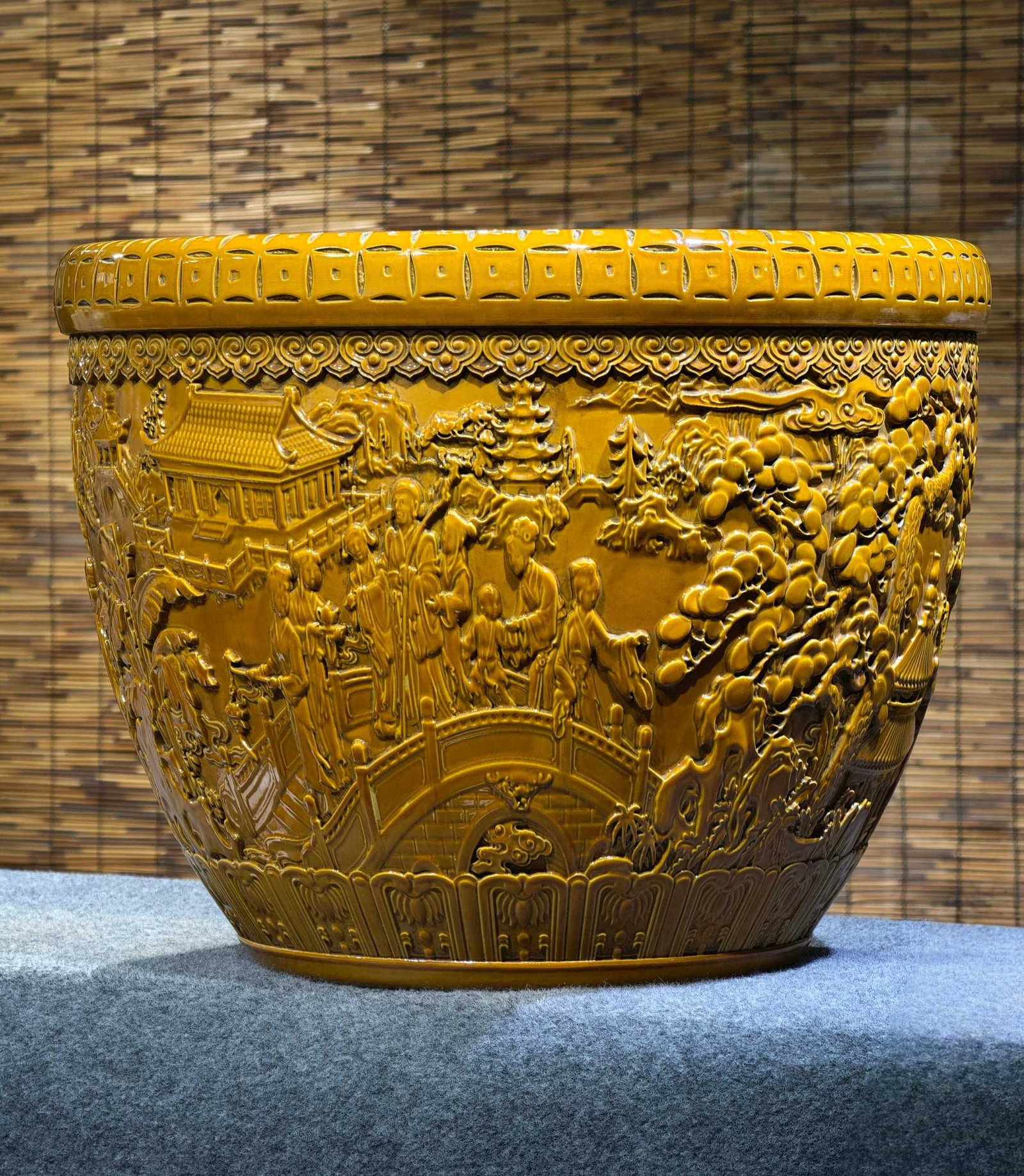 A large yellow-glazed porcelain jar with relief carving of figures and stories, bearing the mark: A large yellow-glazed porcelain jar with relief carving of figures and stories, bearing the mark "Made in the Qianlong Reign of the Great Qing Dynasty," measuring 42 cm in height and 55 cm in width. P