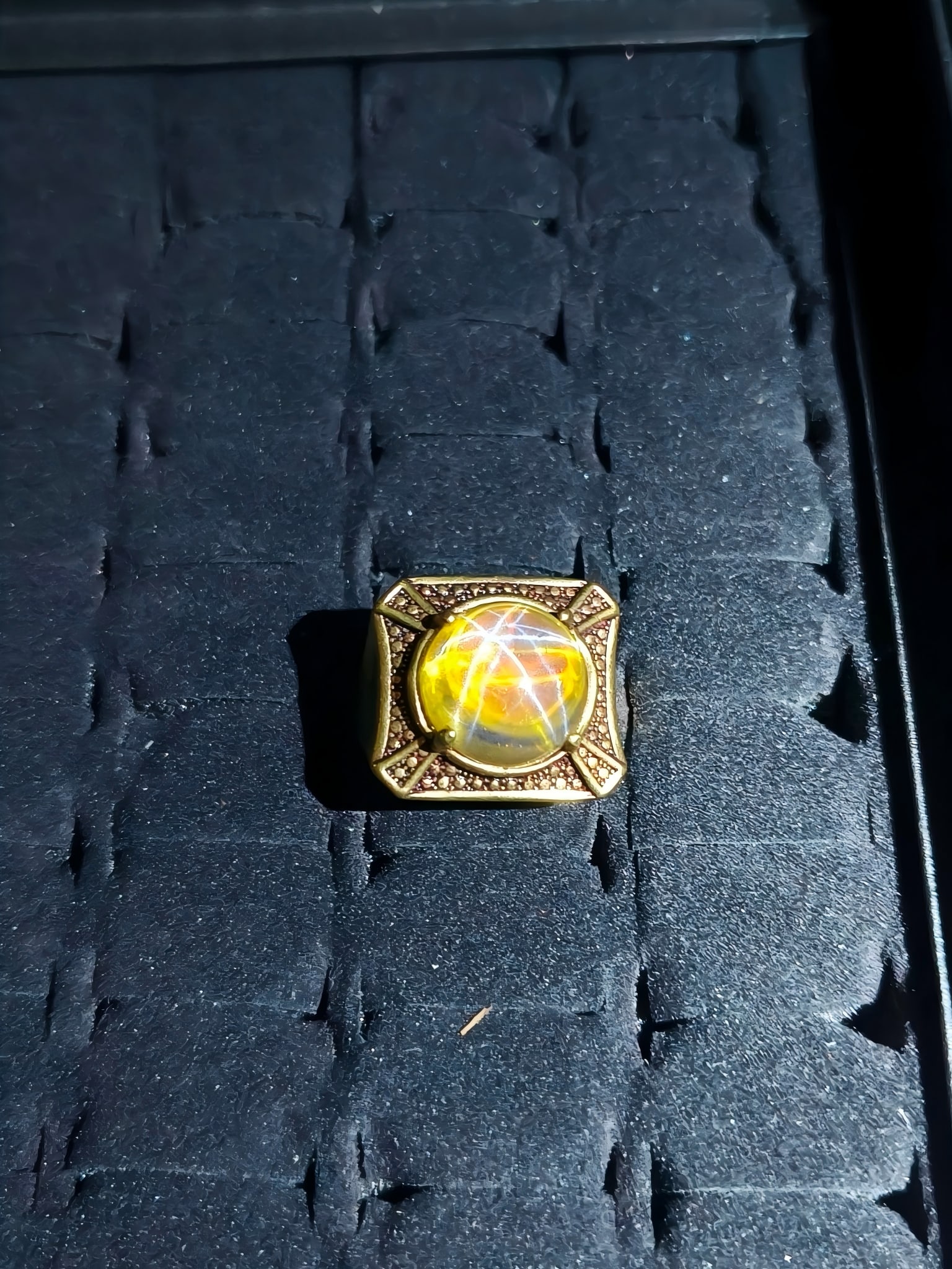 Formerly in the collection: Gilt bronze ring made during the Qianlong period, inlaid with star: This is a 25g Qianlong-era gilt bronze ring inlaid with star gemstones. The ring has an adjustable size. The main gemstone exhibits a pronounced star effect, and the gilt bronze setting has a rich, ag