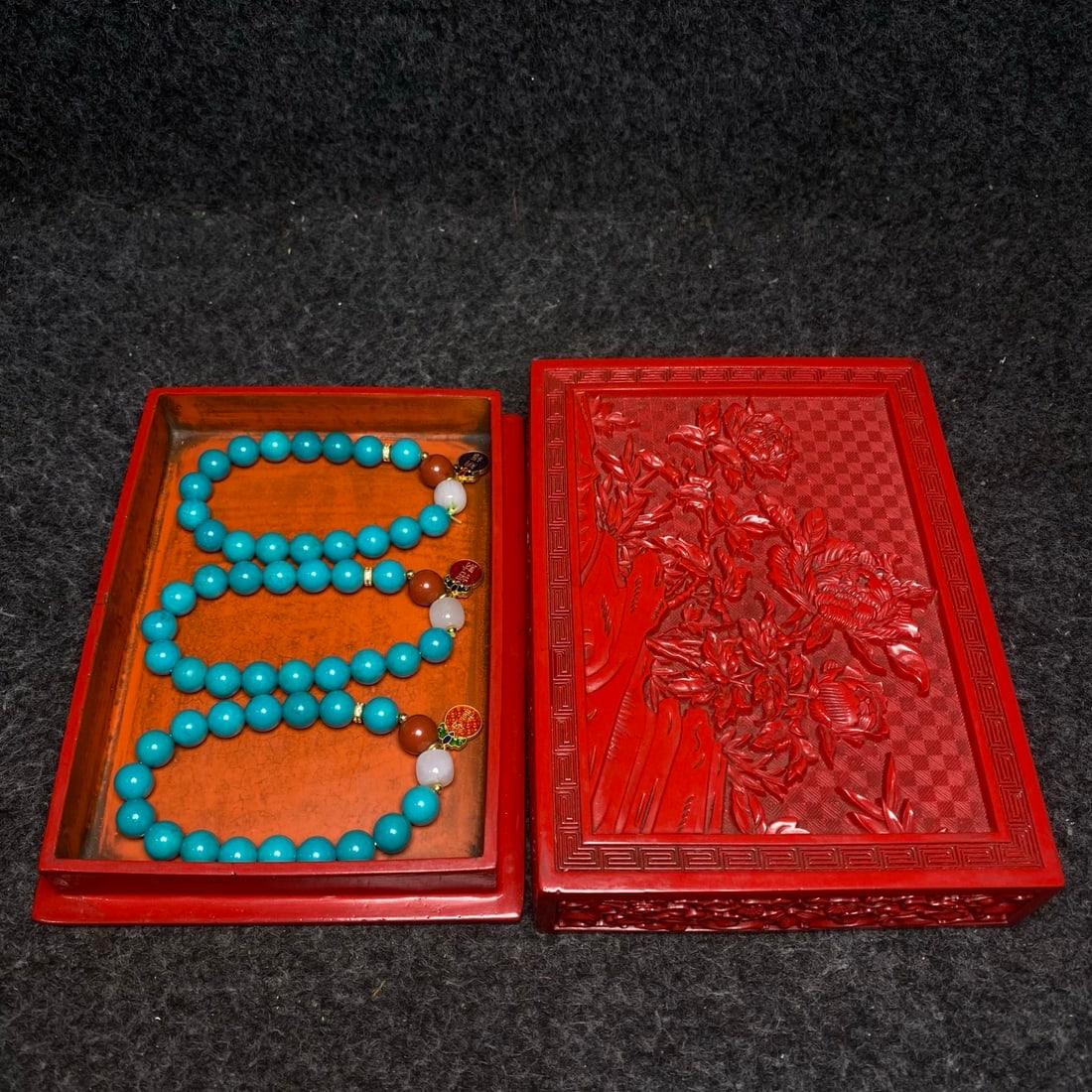 A turquoise bracelet is treasured inside a box containing carved lacquerware made for the imperial: A turquoise bracelet, a treasured piece from a royal lacquerware collection box. Bracelet dimensions: 10mm diameter. Jewelry box dimensions: 17/12.5/4cm (L/W/H). Provenance:From an old private collect