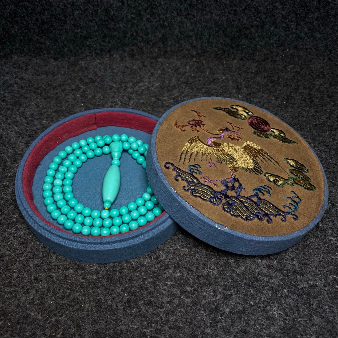 A turquoise necklace treasured in a royal embroidery collection box.: A turquoise necklace treasured in a royal embroidery box. Necklace dimensions: 9mm in diameter. Box dimensions: 16cm in diameter, 5cm in height. Provenance:Private collection from a professor in Unive
