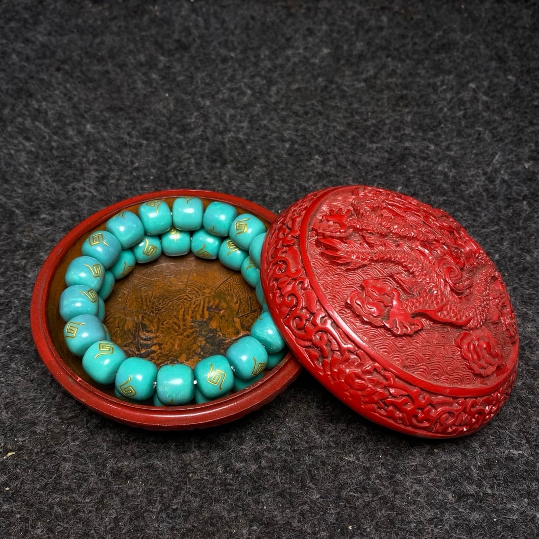 A turquoise bracelet is preserved inside a carved red lacquerware dragon pattern collection box. (1 of 9)