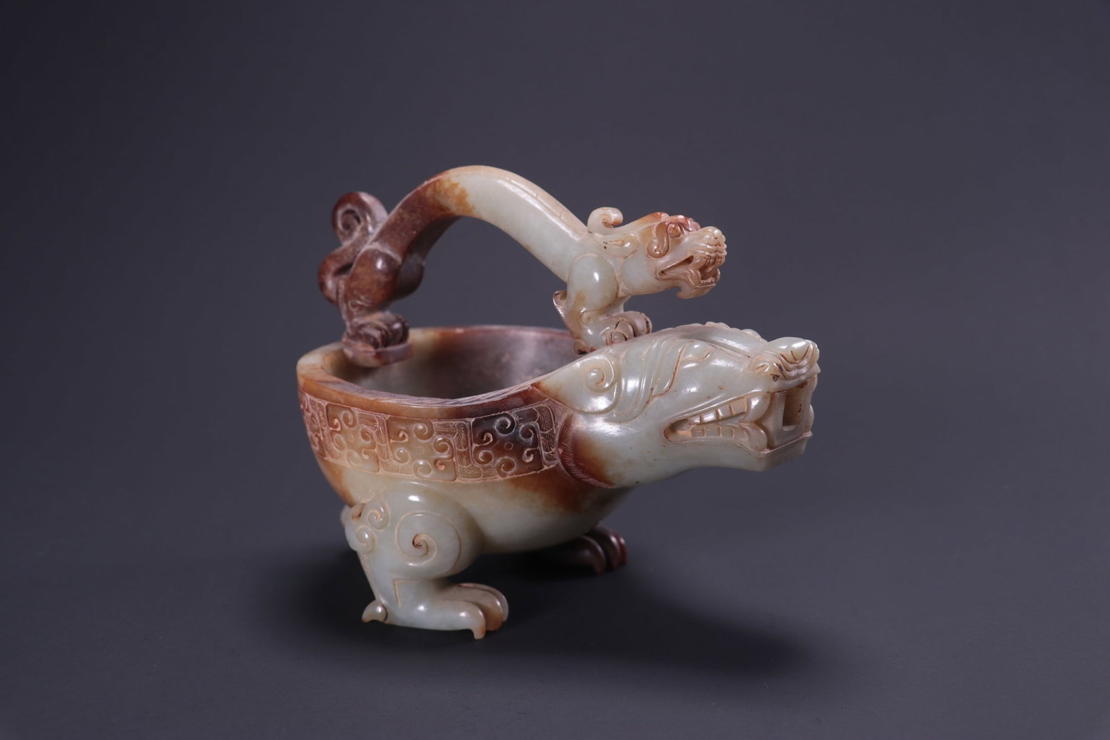 Formerly in the collection of Hetian jade wine vessel with dragon design: The dimensions of the Hetian jade wine vessel with dragon design (formerly in the collection) are: length 16.3cm, width 10.5cm, height 12.5cm, and weight 739g. Provenance:Private collection, Liverpool