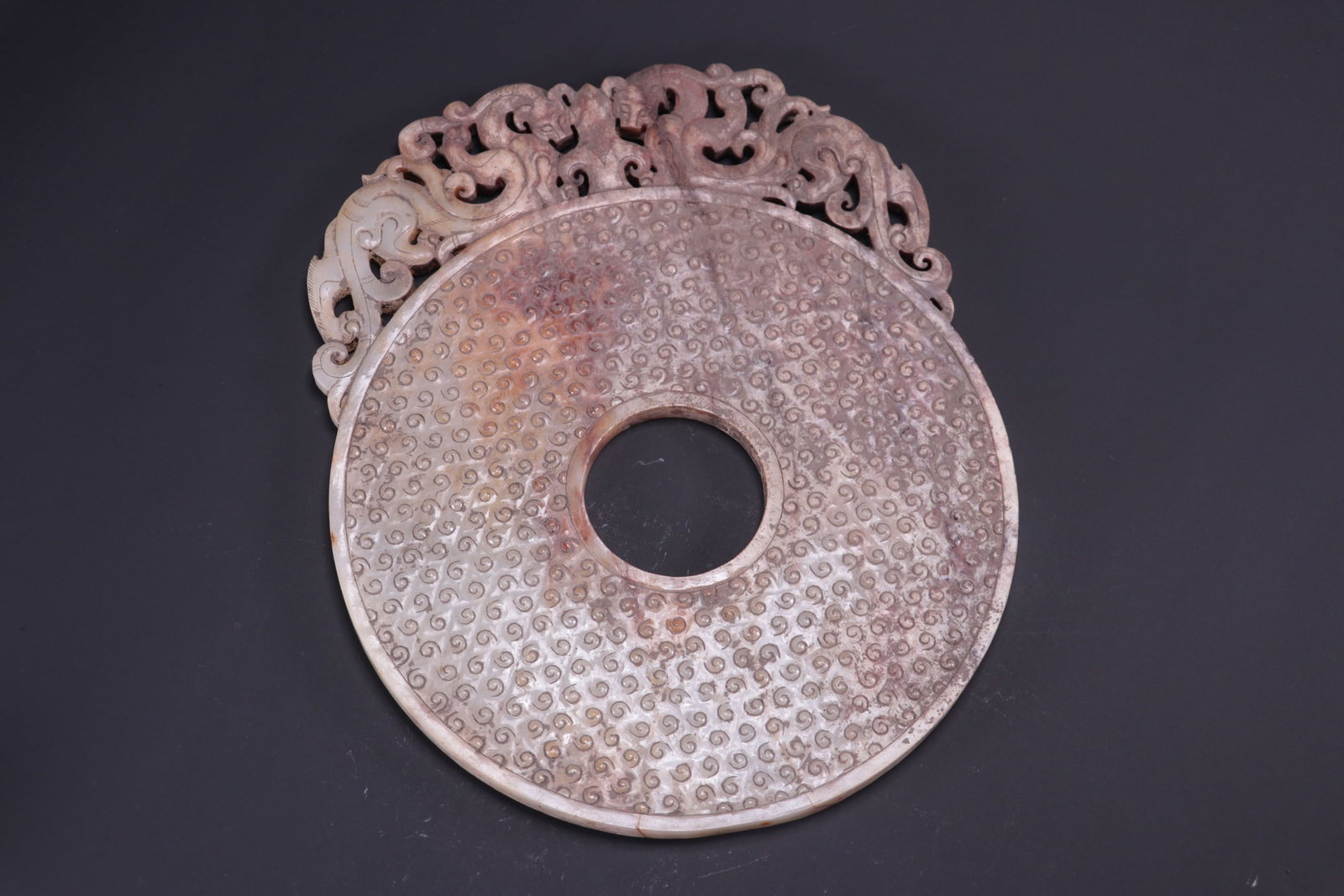 Formerly collected ancient jade bi disc with interlocking patterns: Formerly in the collection, this ancient jade bi disc with interlocking patterns measures 24cm in length, 20.5cm in width, and 1cm in thickness, weighing 862g. Provenance:Private collection, Liverpool