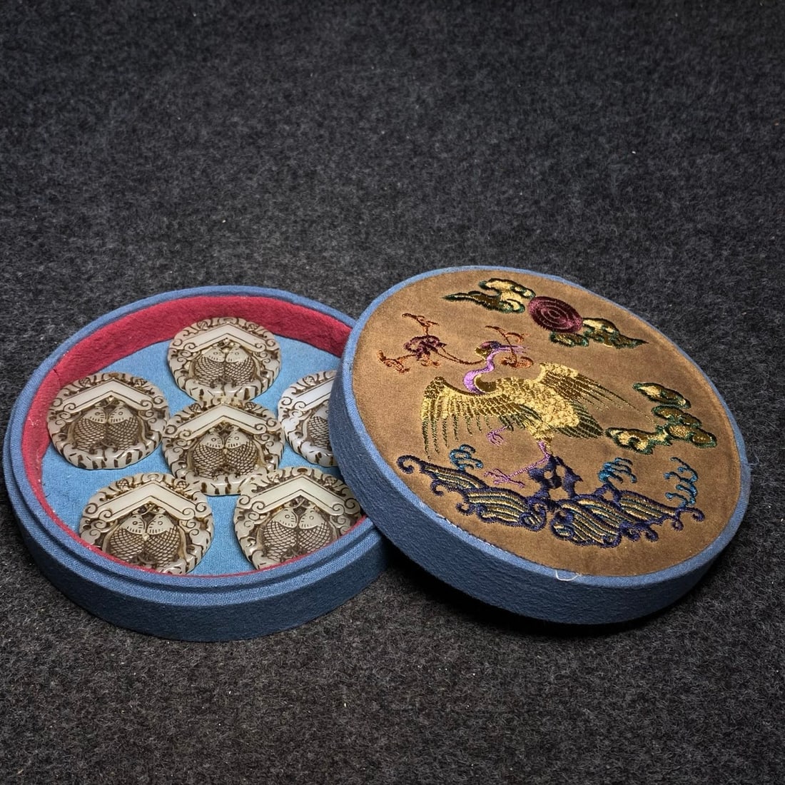 The exquisite embroidered box contains a precious ancient jade bi pendant.: The exquisite embroidered box contains a precious ancient jade bi (disc) pendant. The bi's dimensions are: diameter 4.8cm. The jewelry box's dimensions are: diameter 16cm, height 4.5cm. Provenance:Pri