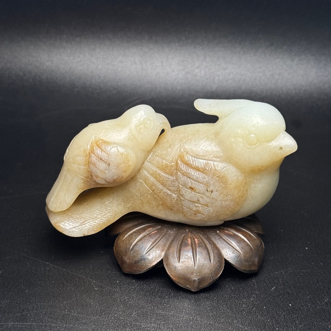 Hetian jade hand-held quail: This Hetian jade hand-held quail carving depicts a mother and her quail, symbolizing a peaceful and prosperous life. The piece is well-proportioned, vividly crafted, and features a warm, lustrous jade