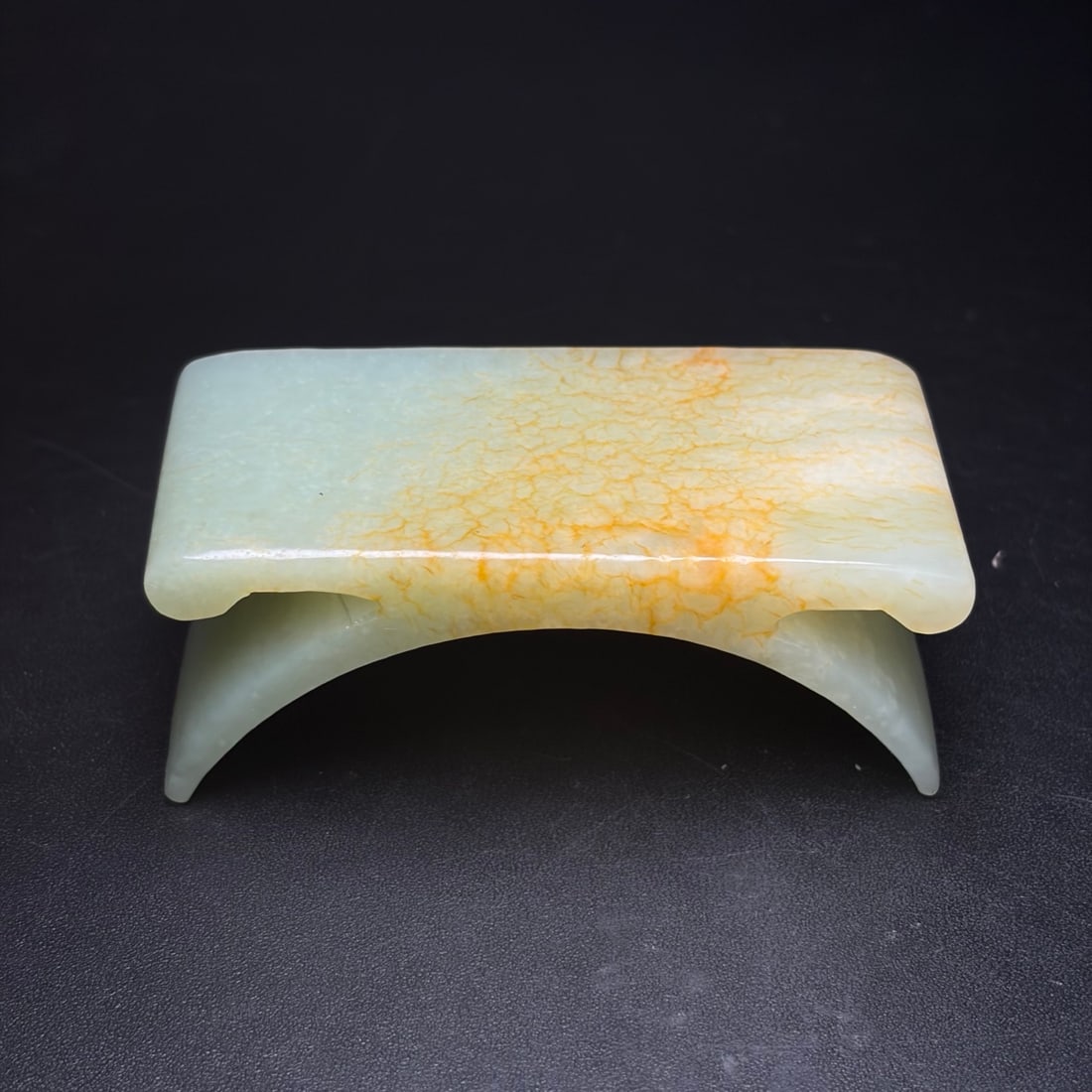 Hotan jade ink bed: This Hetian jade inkstone rest is an elegant scholar's desk accessory. It boasts a beautiful shape, vivid and fluid craftsmanship, fine jade texture, and a rich patina. Dimensions: 79 x 32 x 39 mm; We