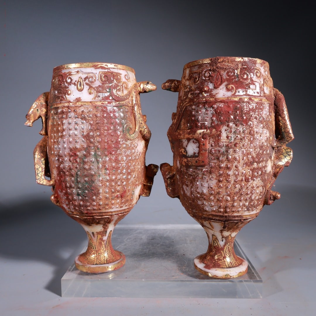 A pair of Warring States and Han Dynasty white jade gilt silver unearthed rust round-carved: A pair of Warring States and Han Dynasty white jade gilt silver unearthed rust round-carved dragon-patterned stemmed wine cups, 16cm high, 11cm wide, weighing 1381g. Provenance:Private collection, Man