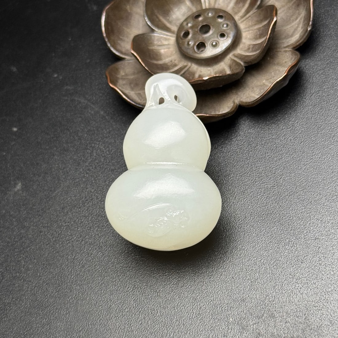Hetian jade gourd pendant: This Hetian jade gourd pendant has a warm, smooth, and oily texture, with a full and well-proportioned shape. It features a cleverly carved gourd design with openwork details, and the belly surface is