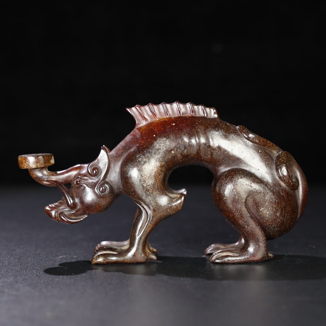 Former Collection of Hetian Jade Auspicious Beasts: This old Hetian jade auspicious beast piece has a delicate and oily texture, with a well-developed patina. It measures 16.6cm in length, 4cm in width, and 9cm in height, and weighs 417g. Provenance:Pr