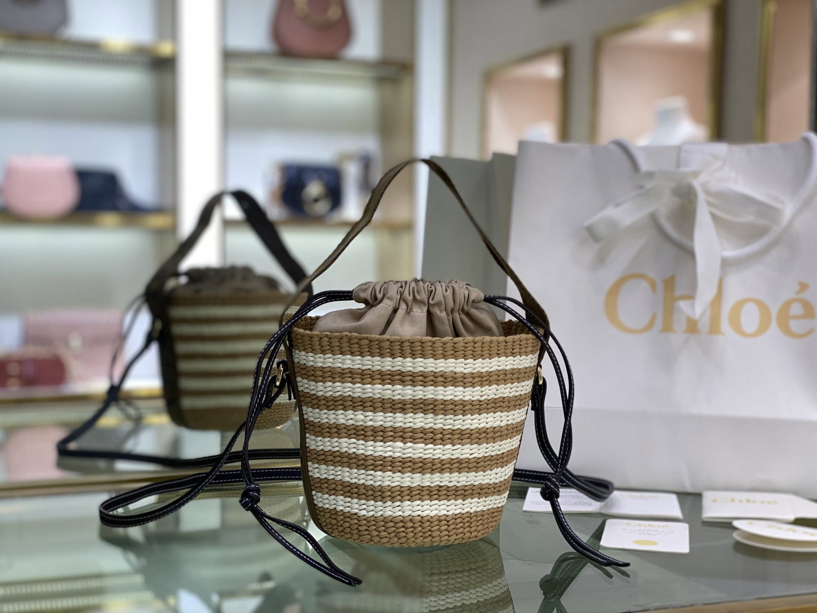 Chloe Small Woody Basket: We offer FREE SHIPPING for both domestic and international clients who bid over $500. The Chloe Small Woody Basket is a woven basket/bucket bag adorned with a Woody ribbon, offering versatility in car