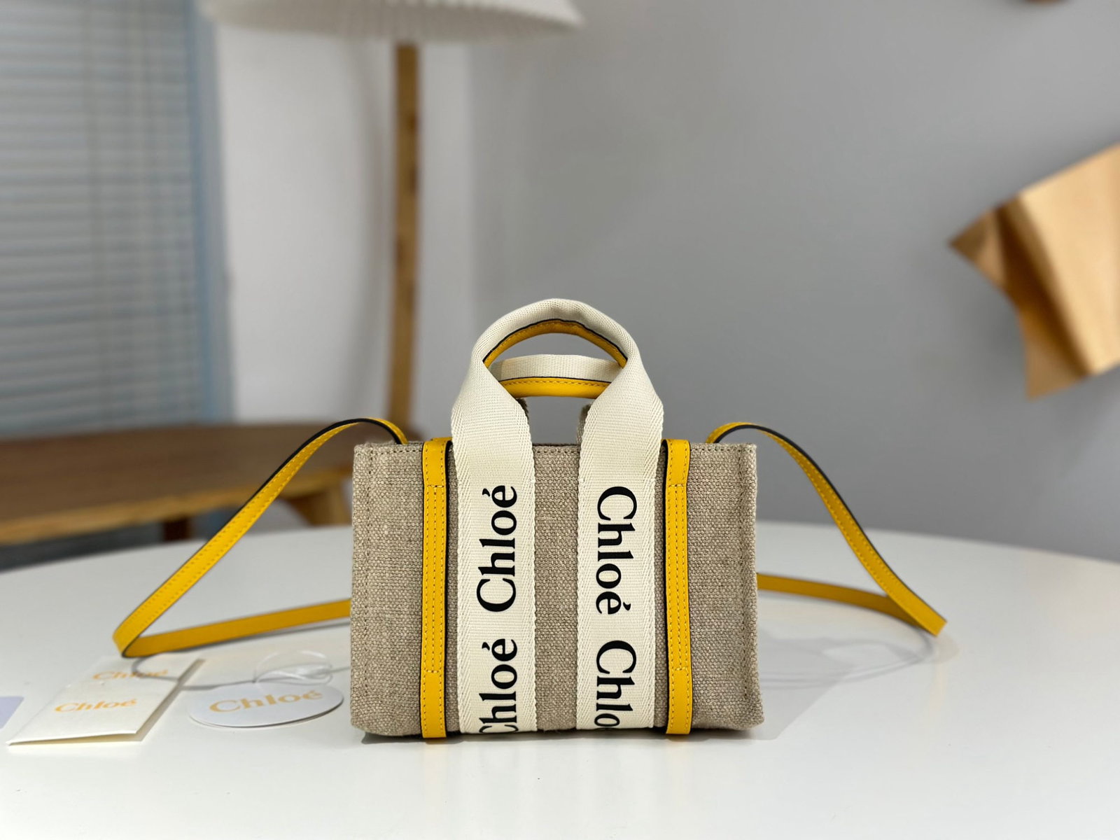 Chloe Woody: We offer FREE SHIPPING for both domestic and international clients who bid over $500. This mini cream-yellow Chloe Woody tote bag features the classic Woody series letter ribbon. It's crafted from eco