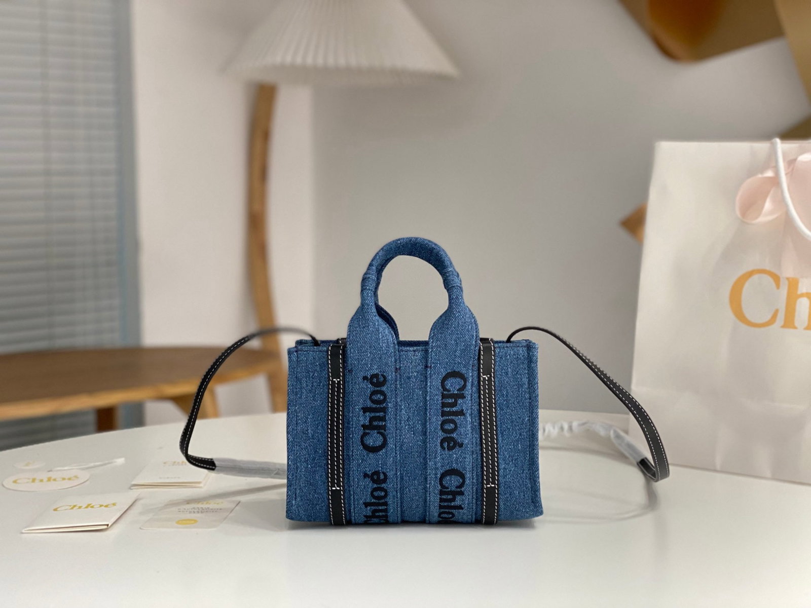 Chloe Woody: We offer FREE SHIPPING for both domestic and international clients who bid over $500. The mini Chloe Woody denim blue tote bag with a long shoulder strap features the iconic Chloe logo embroidered on 