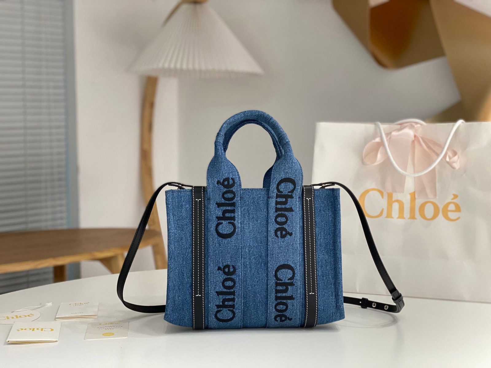 Chloe Woody: We offer FREE SHIPPING for both domestic and international clients who bid over $500. The Chloe Woody denim blue tote bag with a long shoulder strap features the iconic Chloe logo embroidered on a den