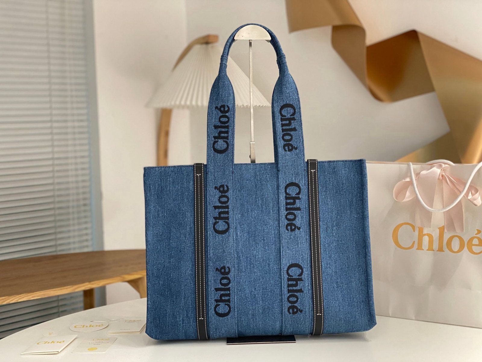 Chloe Woody: We offer FREE SHIPPING for both domestic and international clients who bid over $500. The Chloe Woody denim blue tote bag features the iconic Chloe logo embroidered on a denim blue ribbon, giving it a
