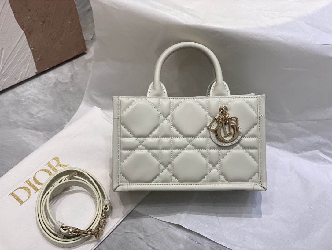 Christian Dior Book Tote: We offer FREE SHIPPING for both domestic and international clients who bid over $500. The off-white mini Dior Book Tote bag is a classic original design by Dior Creative Director Maria Grazia Chiuri. 