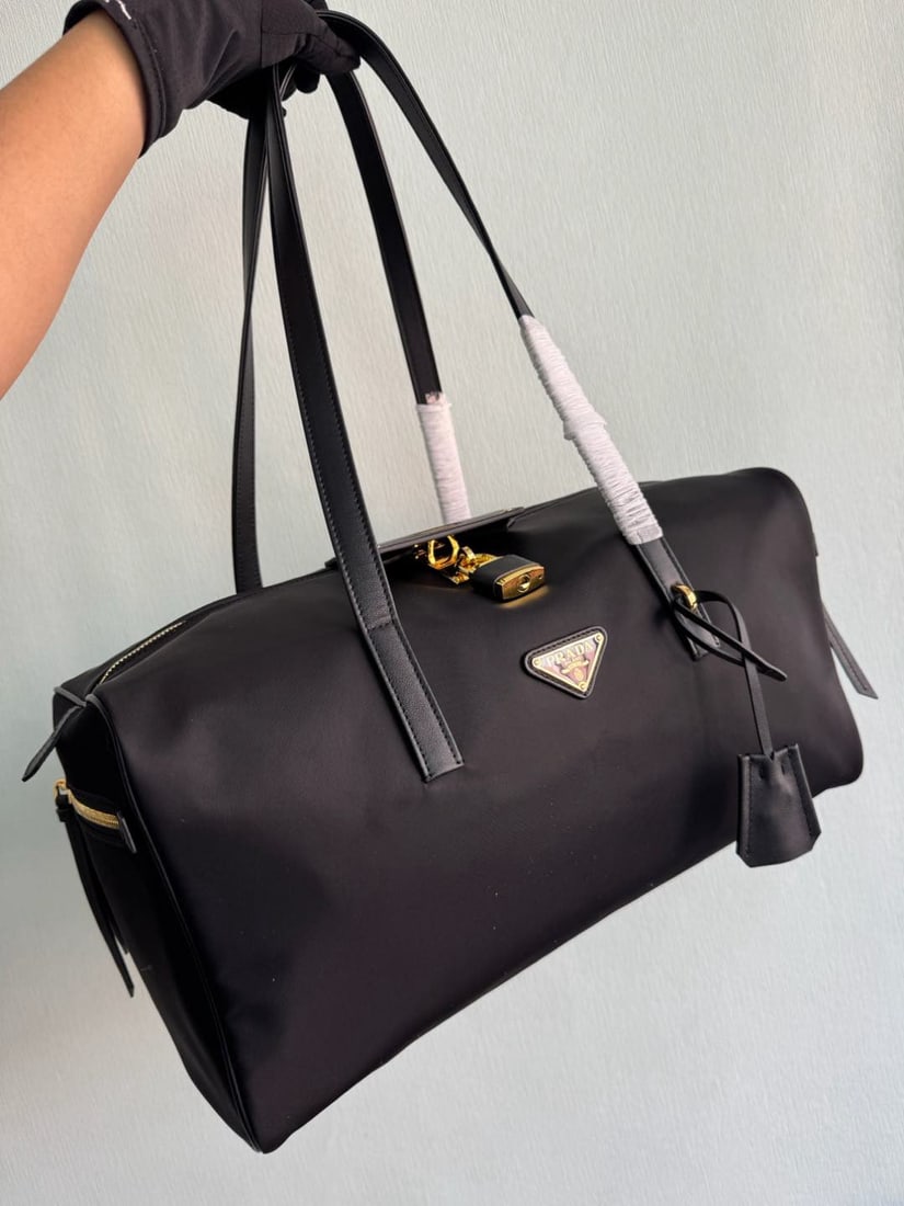 PRADA Nylon Travel Bag: We offer FREE SHIPPING for both domestic and international clients who bid over $500. The Re-Nylon Travel Bag is a lifelike design featuring functional details and leather trim. The spacious interior 