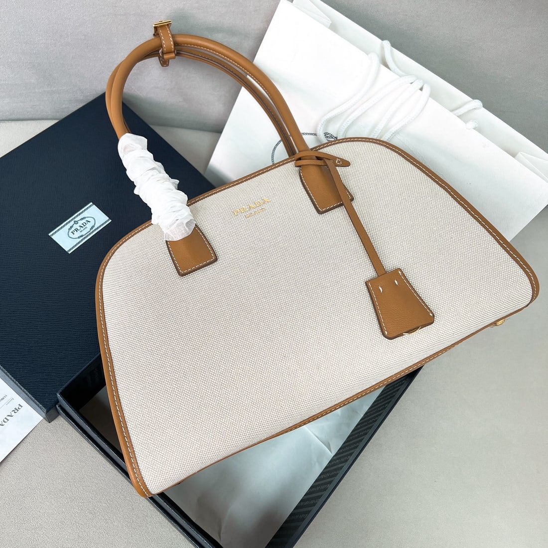 PRADA tote bag: We offer FREE SHIPPING for both domestic and international clients who bid over $500. This tote bag combines the versatility and lightweight feel of a cowhide and linen blend, creating an oversized si
