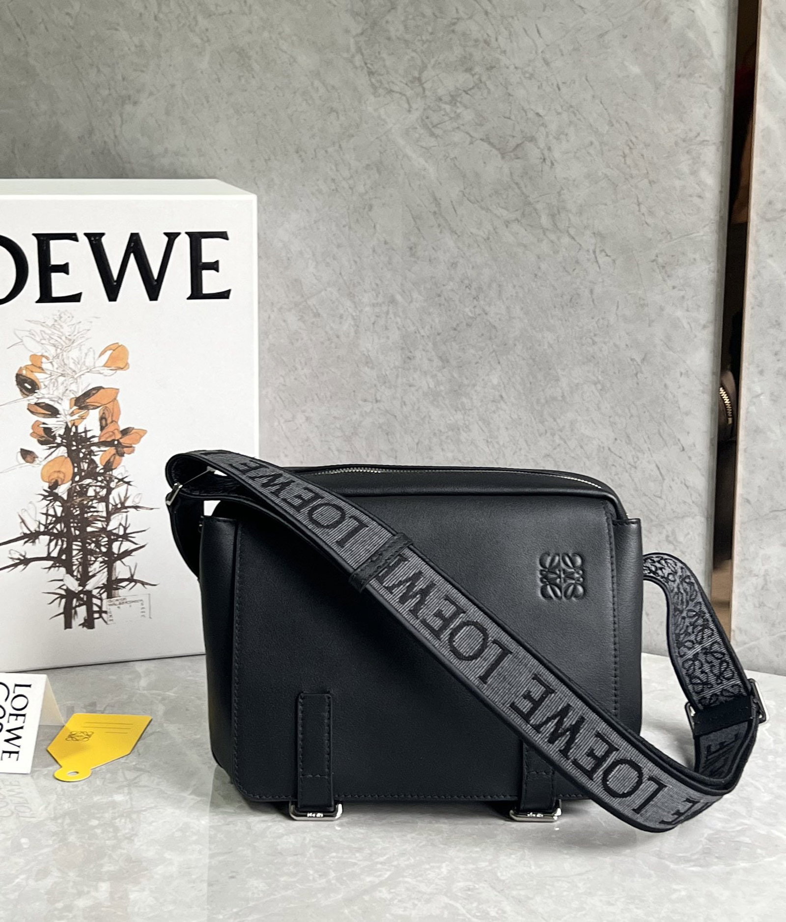 LOEWE: We offer FREE SHIPPING for both domestic and international clients who bid over $500. LOEWE messenger bag, crafted from pebbled calfskin with a jacquard embroidered shoulder strap. The adjustable shou