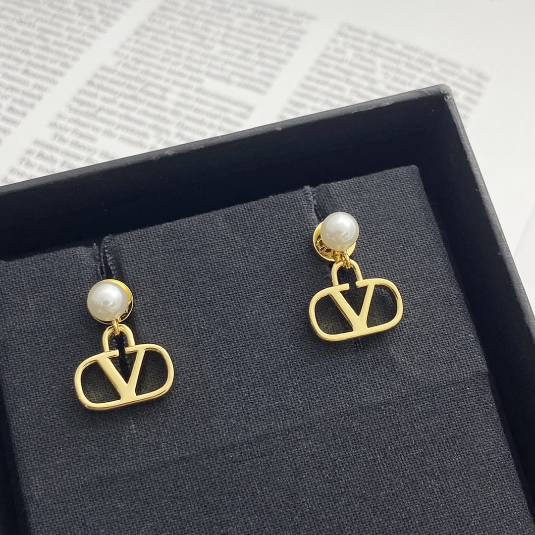 Valentino earrings: We offer FREE SHIPPING for both domestic and international clients who bid over $500. Valentino pearl V-shaped earrings feature small pearls suspended in the iconic V-shape, softening the inherent